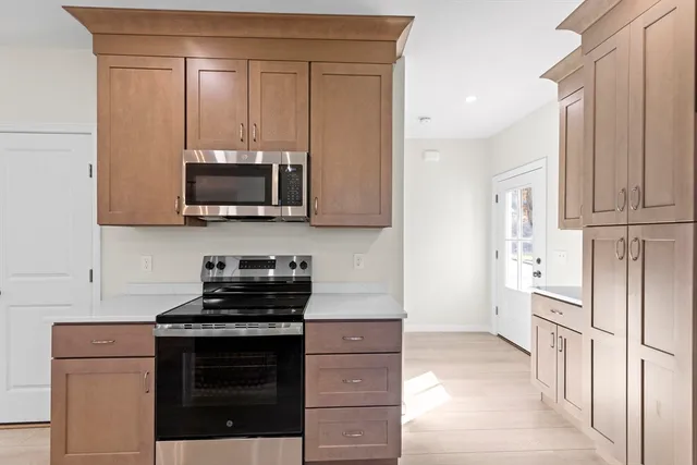 a kitchen with stainless steel appliances granite countertop a stove a microwave and a refrigerator