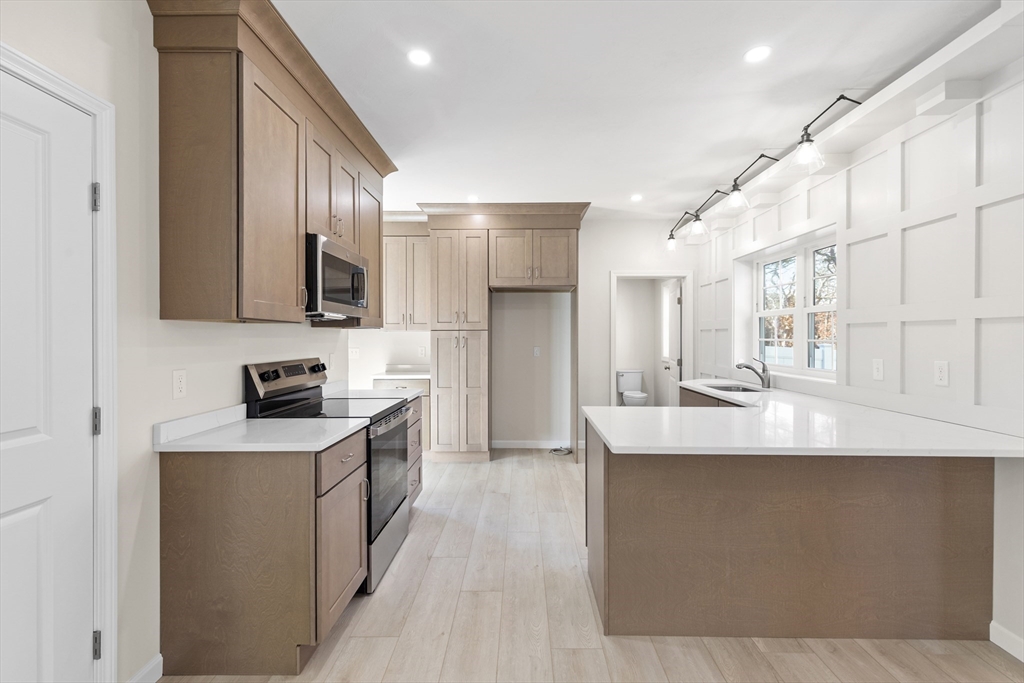 1234 State Road, Unit 1 Plymouth, MA 02360 - Photo 12 of 32 a kitchen with stainless steel appliances granite countertop a sink a stove and a refrigerator