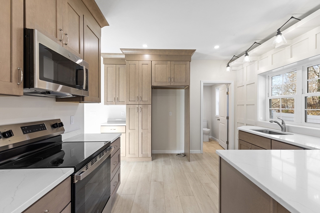 1234 State Road, Unit 1 Plymouth, MA 02360 - Photo 5 of 32 a kitchen with stainless steel appliances a stove microwave and sink