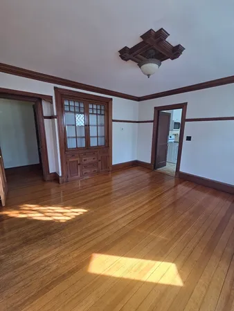 a view of empty room with wooden floor