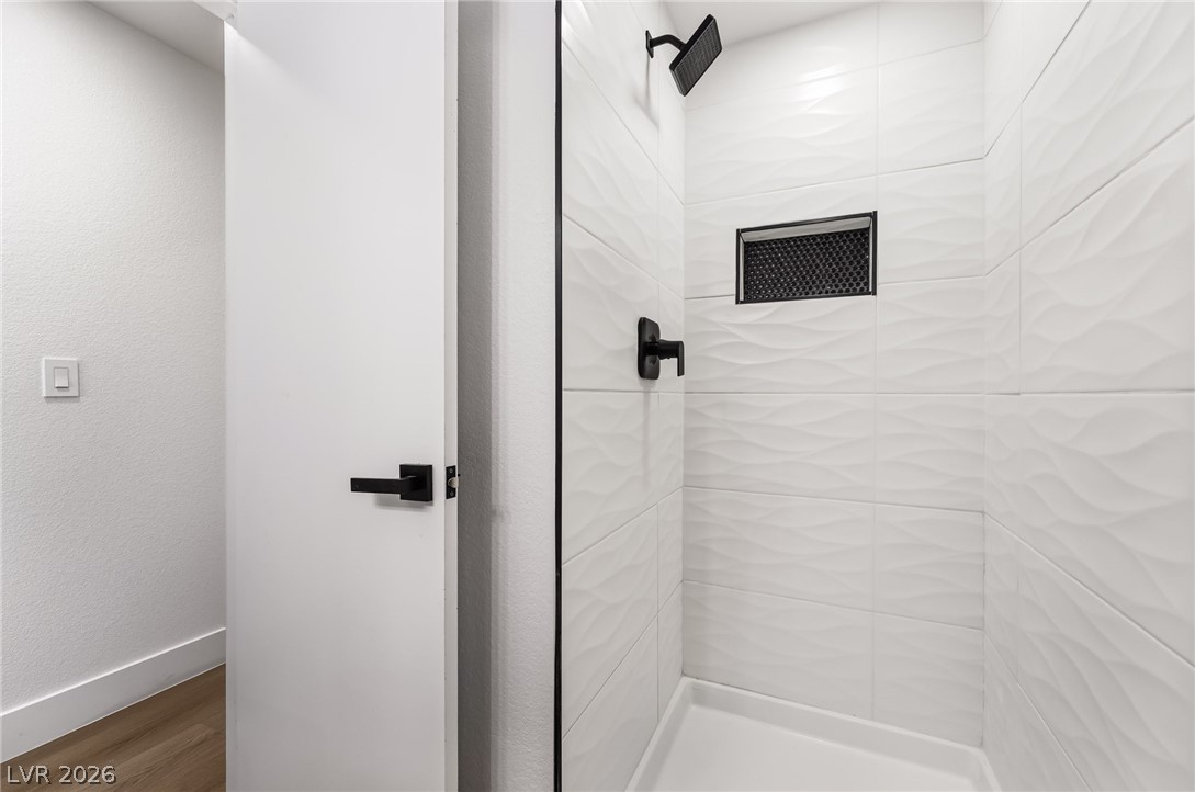429 Crestway Road Henderson, NV 89015 - Photo 34 of 56 A chic, walk-in shower features textured tile and matte black fixtures.