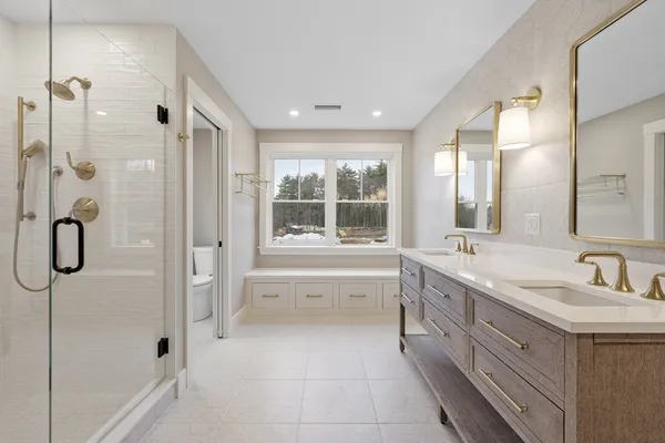 a bathroom with a tub sink shower and mirror