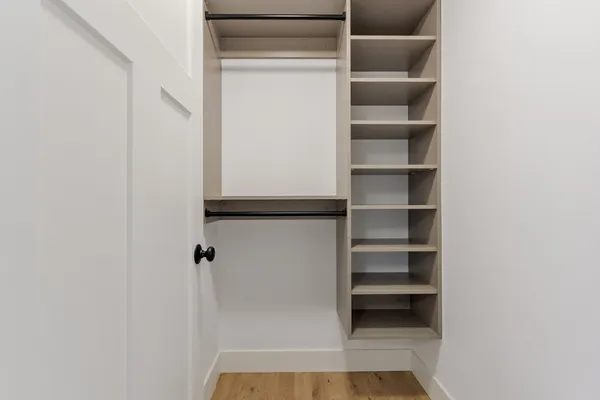a view of walk in closet with empty racks