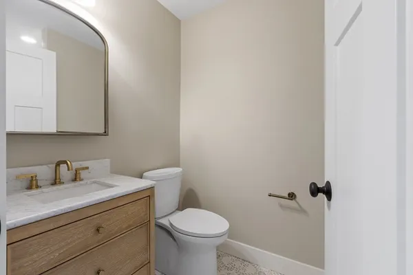 a bathroom with a toilet sink and mirror