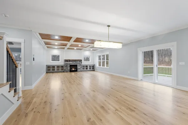 a view of a big room with wooden floor kitchen view and windows