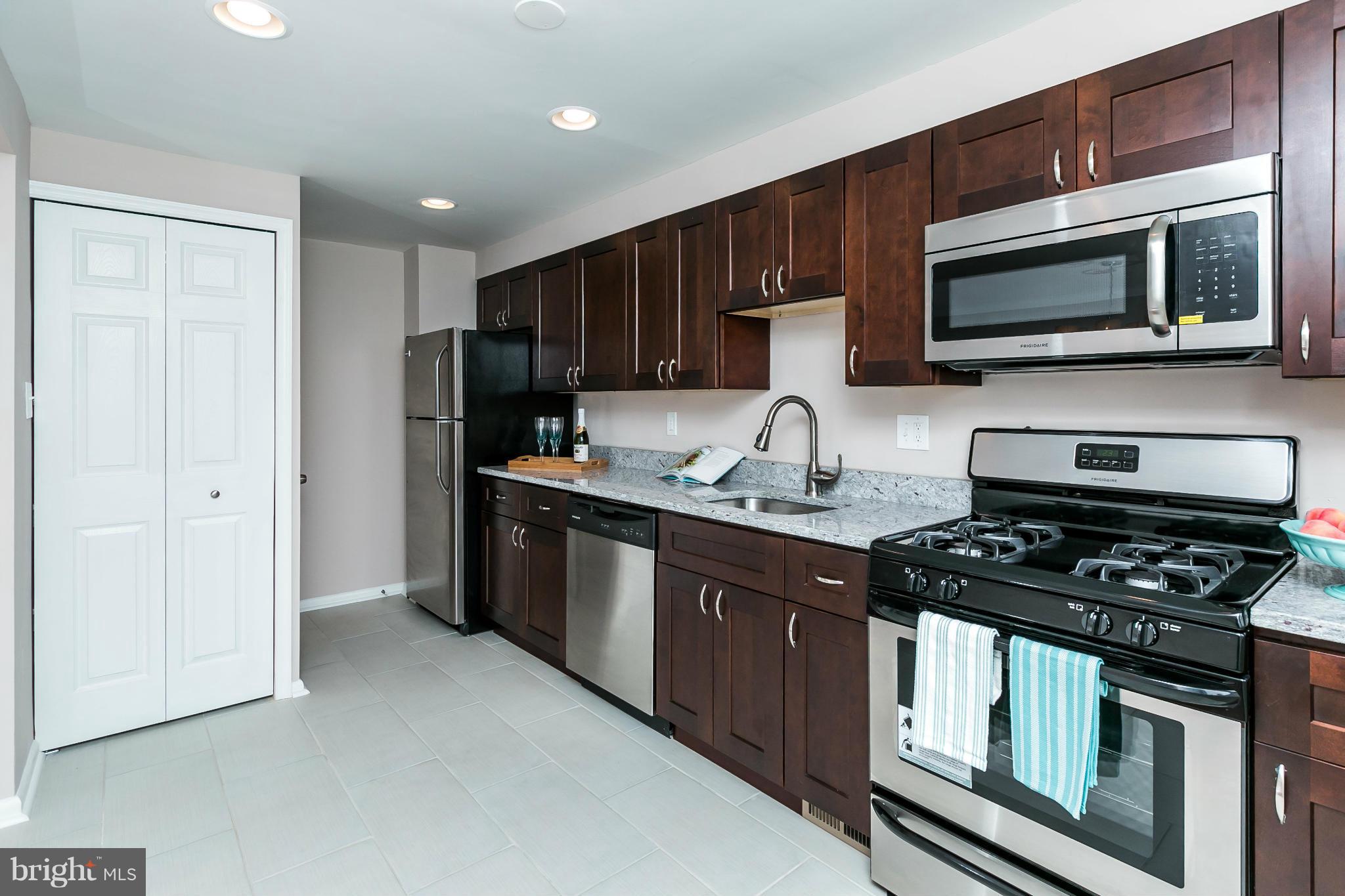 5417 Bucknell Road Baltimore, MD 21206 - Photo 14 of 30 a kitchen with stainless steel appliances granite countertop a stove a microwave and a refrigerator
