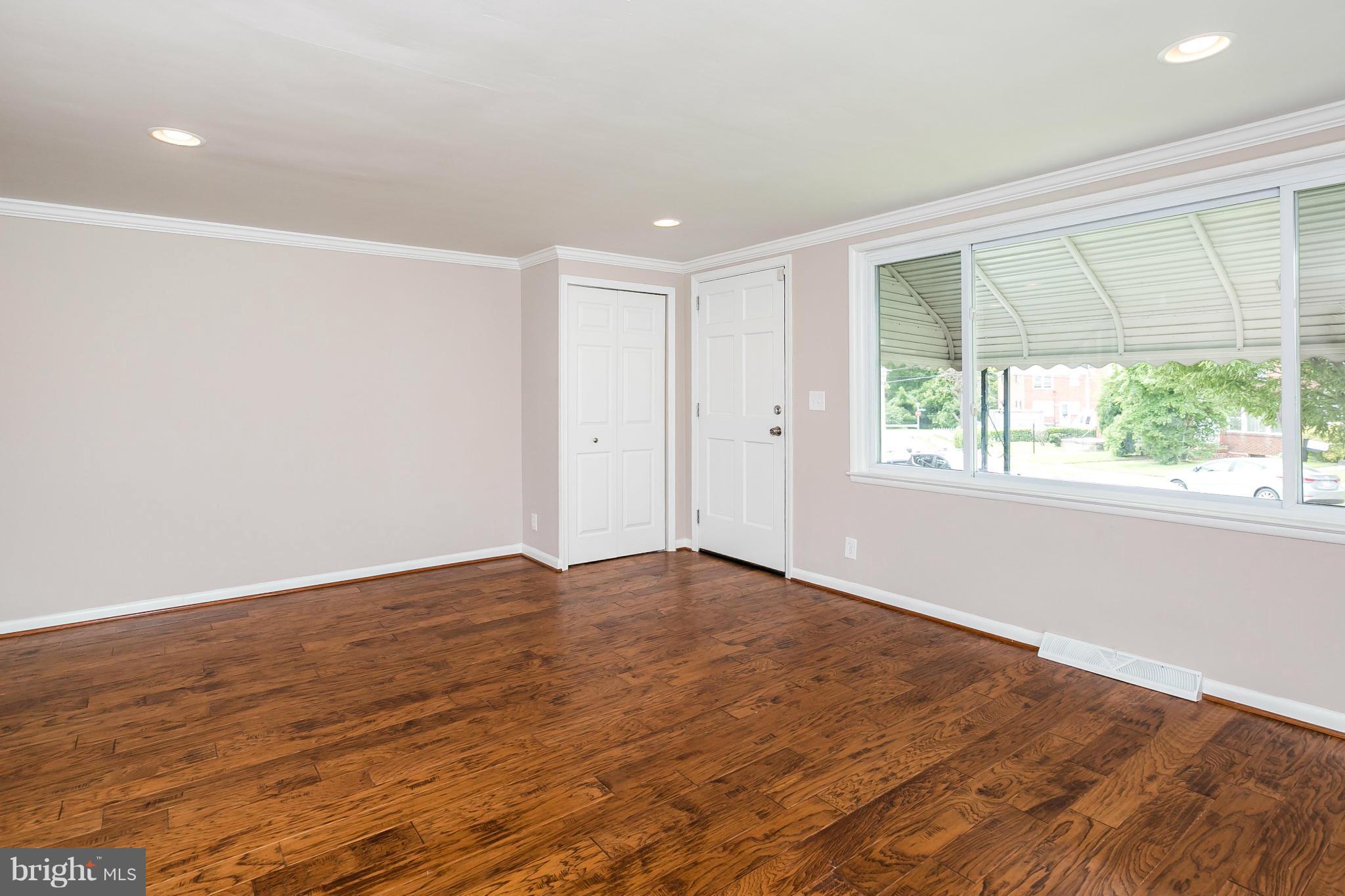5417 Bucknell Road Baltimore, MD 21206 - Photo 5 of 30 a view of an empty room with wooden floor and a window