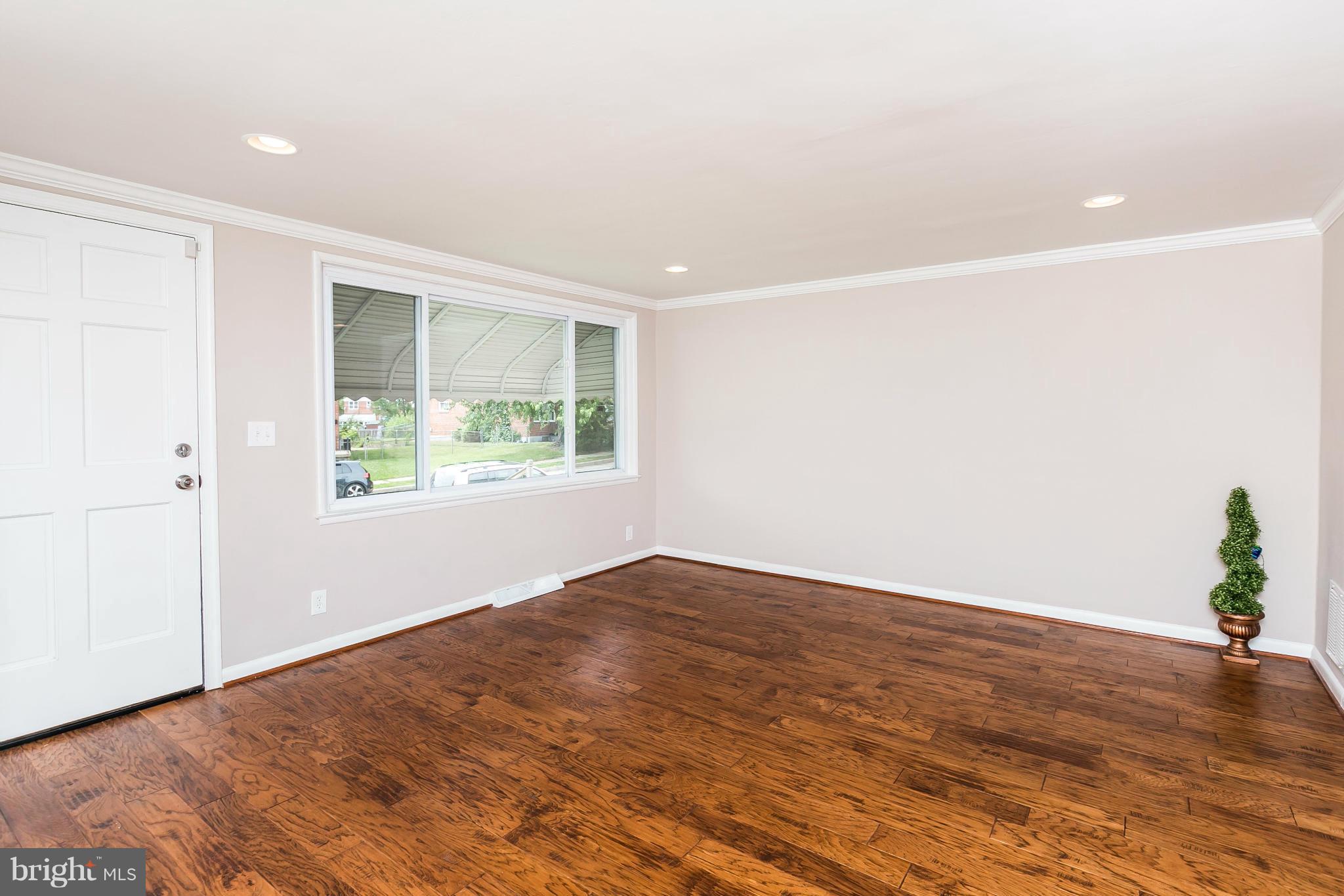 5417 Bucknell Road Baltimore, MD 21206 - Photo 6 of 30 an empty room with wooden floor and windows
