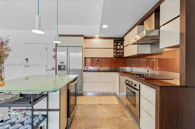 a kitchen with stainless steel appliances a stove a table and chairs
