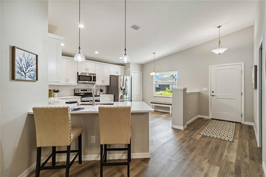 6288 Deer Run Road North Port, FL 34291 - Photo 13 of 43 a living room with stainless steel appliances kitchen island a table chairs and wooden floor