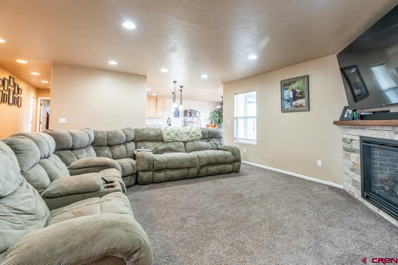 1265 H25 Road Delta, CO 81416 - Photo 11 of 34 a living room with furniture a flat screen tv and a fireplace