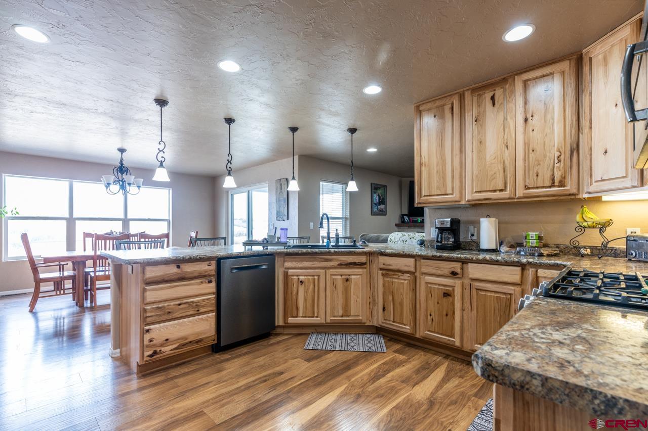 1265 H25 Road Delta, CO 81416 - Photo 21 of 34 a kitchen with stainless steel appliances granite countertop wooden cabinets a stove a sink a dining table and chairs