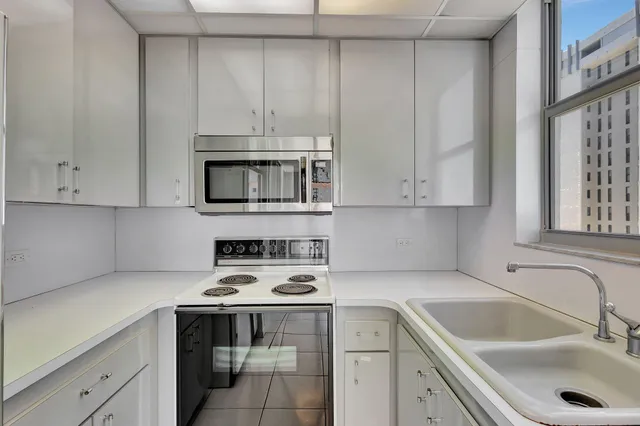 a kitchen with white cabinets a sink and dishwasher