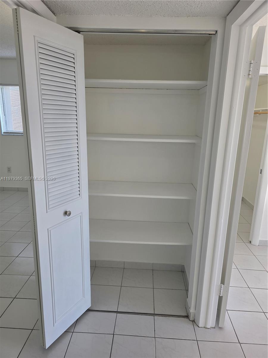 8015 Southwest 107th Avenue, Unit 313 Miami, FL 33173 - Photo 19 of 43 a view of walk in closet with empty racks