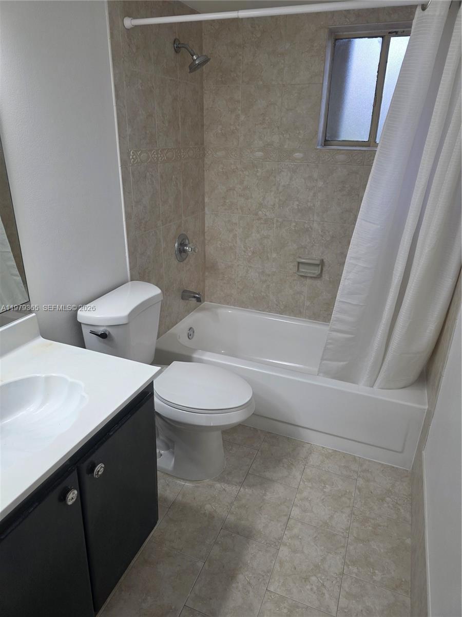 8015 Southwest 107th Avenue, Unit 313 Miami, FL 33173 - Photo 28 of 43 a bathroom with a double vanity sink toilet and shower