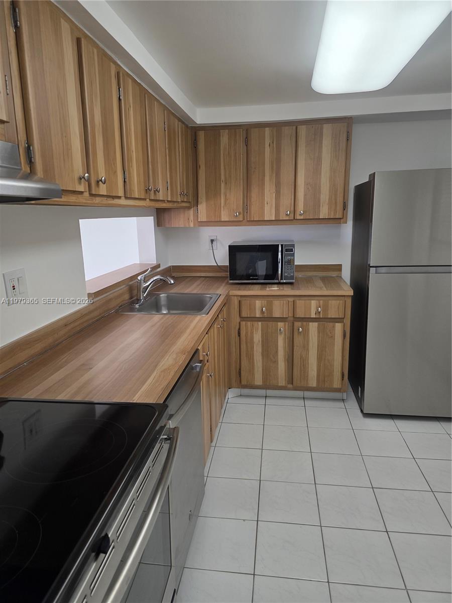 8015 Southwest 107th Avenue, Unit 313 Miami, FL 33173 - Photo 9 of 43 a kitchen with a sink a stove and refrigerator