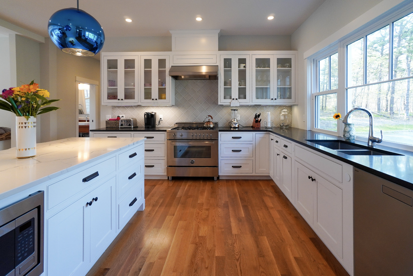 3 Sengekontacket Road Oak Bluffs, MA 02557 - Photo 12 of 34 a large kitchen with stainless steel appliances kitchen island granite countertop a sink dishwasher a stove and white cabinets with wooden floor