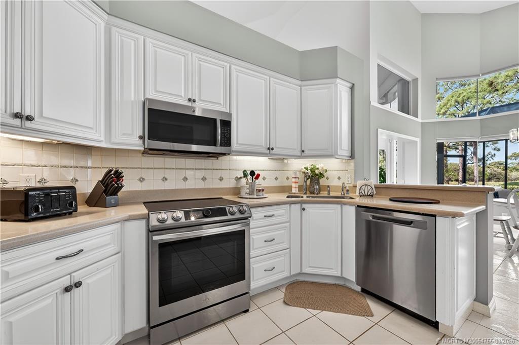13319 Northwest Maplewood Road Palm City, FL 34990 - Photo 12 of 42 a kitchen with granite countertop white cabinets and white stove