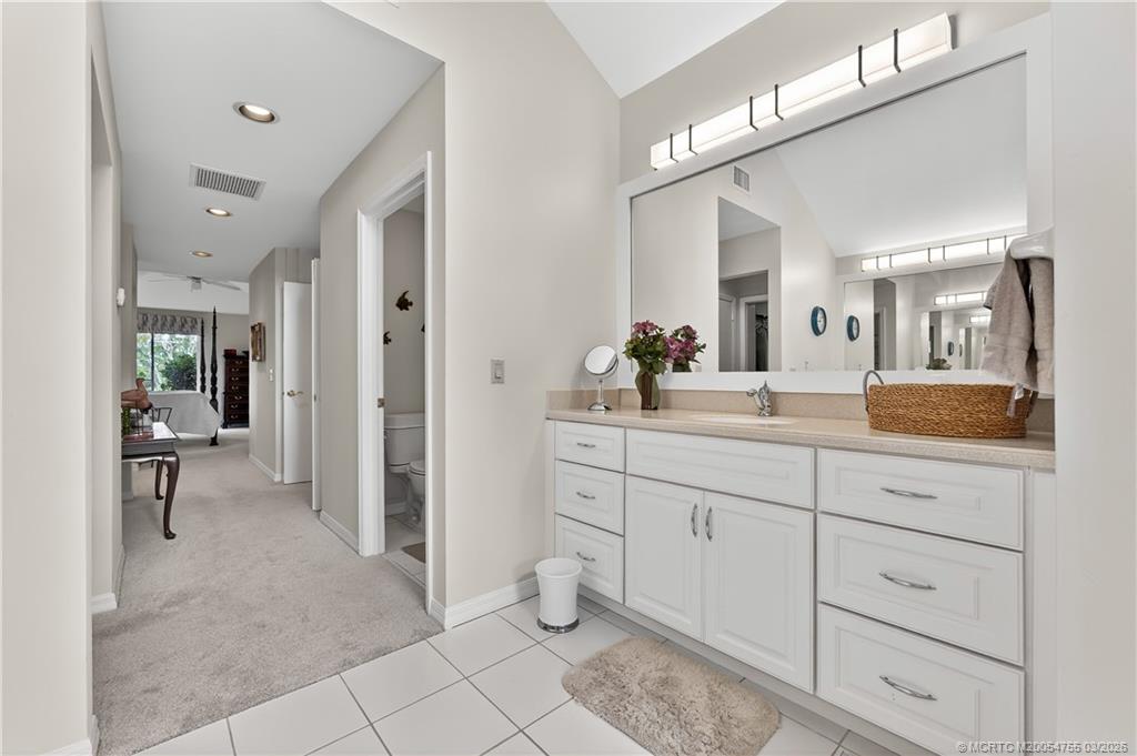 13319 Northwest Maplewood Road Palm City, FL 34990 - Photo 20 of 42 a spacious bathroom with a double vanity sink mirror and toilet