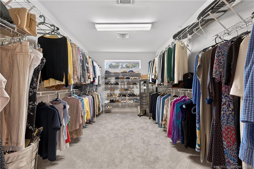 13319 Northwest Maplewood Road Palm City, FL 34990 - Photo 21 of 42 a view of walk in closet with clothes and shoes