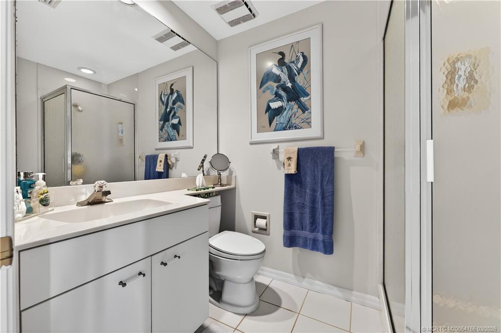 13319 Northwest Maplewood Road Palm City, FL 34990 - Photo 24 of 42 a bathroom with a toilet a sink and mirror