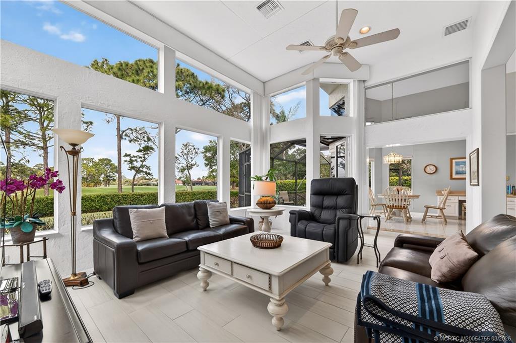 13319 Northwest Maplewood Road Palm City, FL 34990 - Photo 8 of 42 a living room with furniture a chandelier and a large window