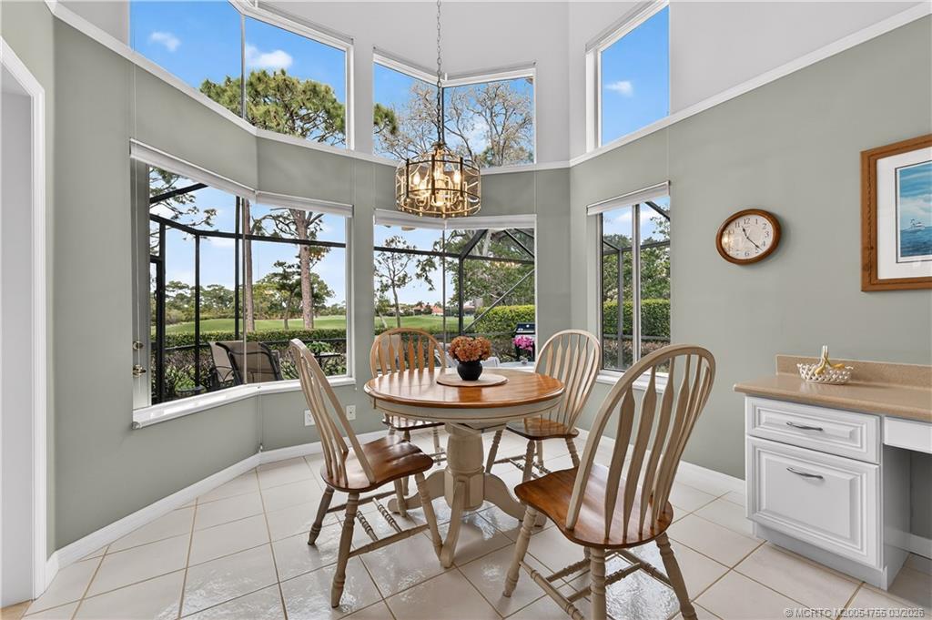 13319 Northwest Maplewood Road Palm City, FL 34990 - Photo 10 of 42 a dining room with furniture a chandelier and window