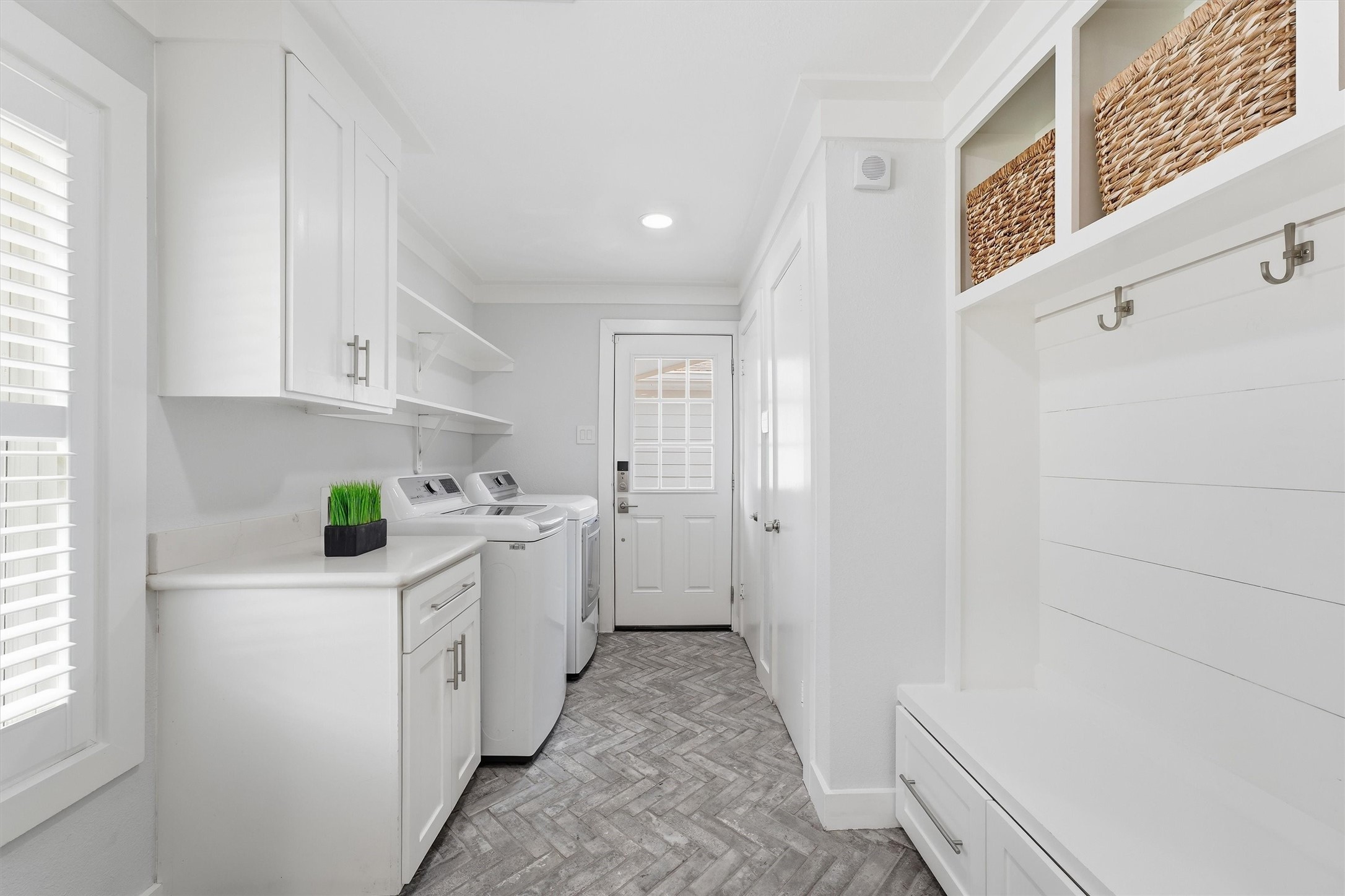 4701 Hummingbird Street Houston, TX 77035 - Photo 11 of 28 Highly functional, the hardworking laundry room does double duty as a drop zone with a dedicated mud area with hooks, shelves, a bench and drawers. A closet is to the right for all your cleaning supplies, while more cabinetry and countertop space complete the room. (Note: There is room for a dog bed or kennel in this area under the window!)