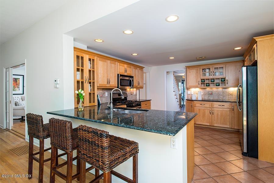 50 Old Orchard Road Riverside, CT 06878 - Photo 13 of 16 a kitchen with stainless steel appliances granite countertop table chairs and a refrigerator