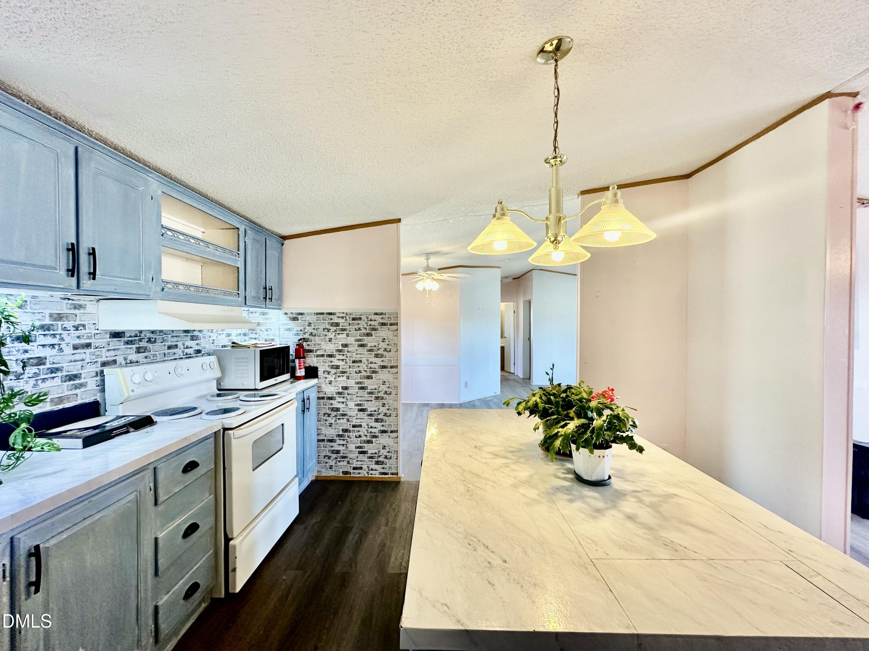 287 Oliver Loop Road Roxboro, NC 27574 - Photo 12 of 26 a kitchen with stainless steel appliances kitchen island granite countertop a stove a sink and a refrigerator