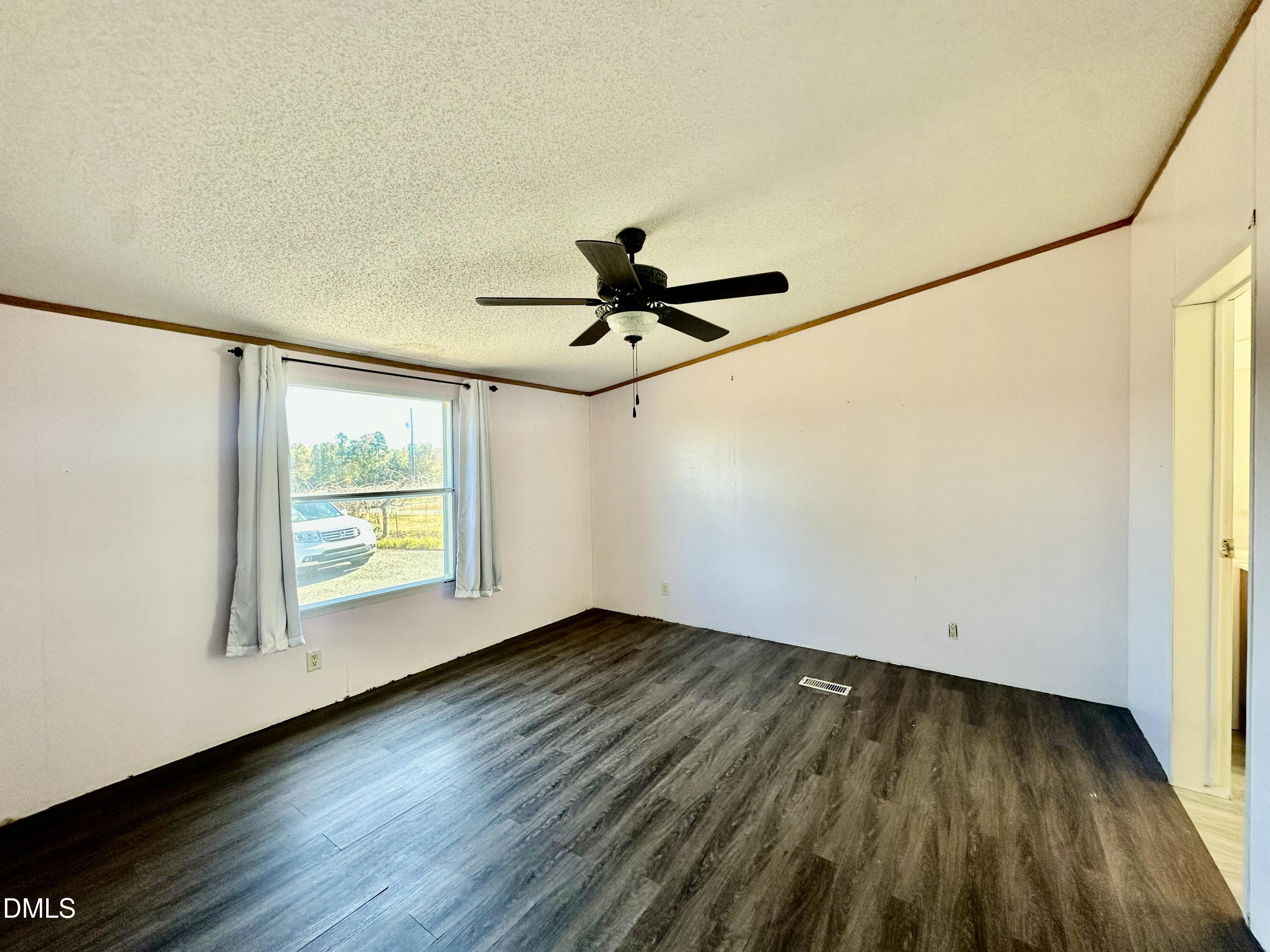 287 Oliver Loop Road Roxboro, NC 27574 - Photo 13 of 26 a view of empty room with wooden floor and fan