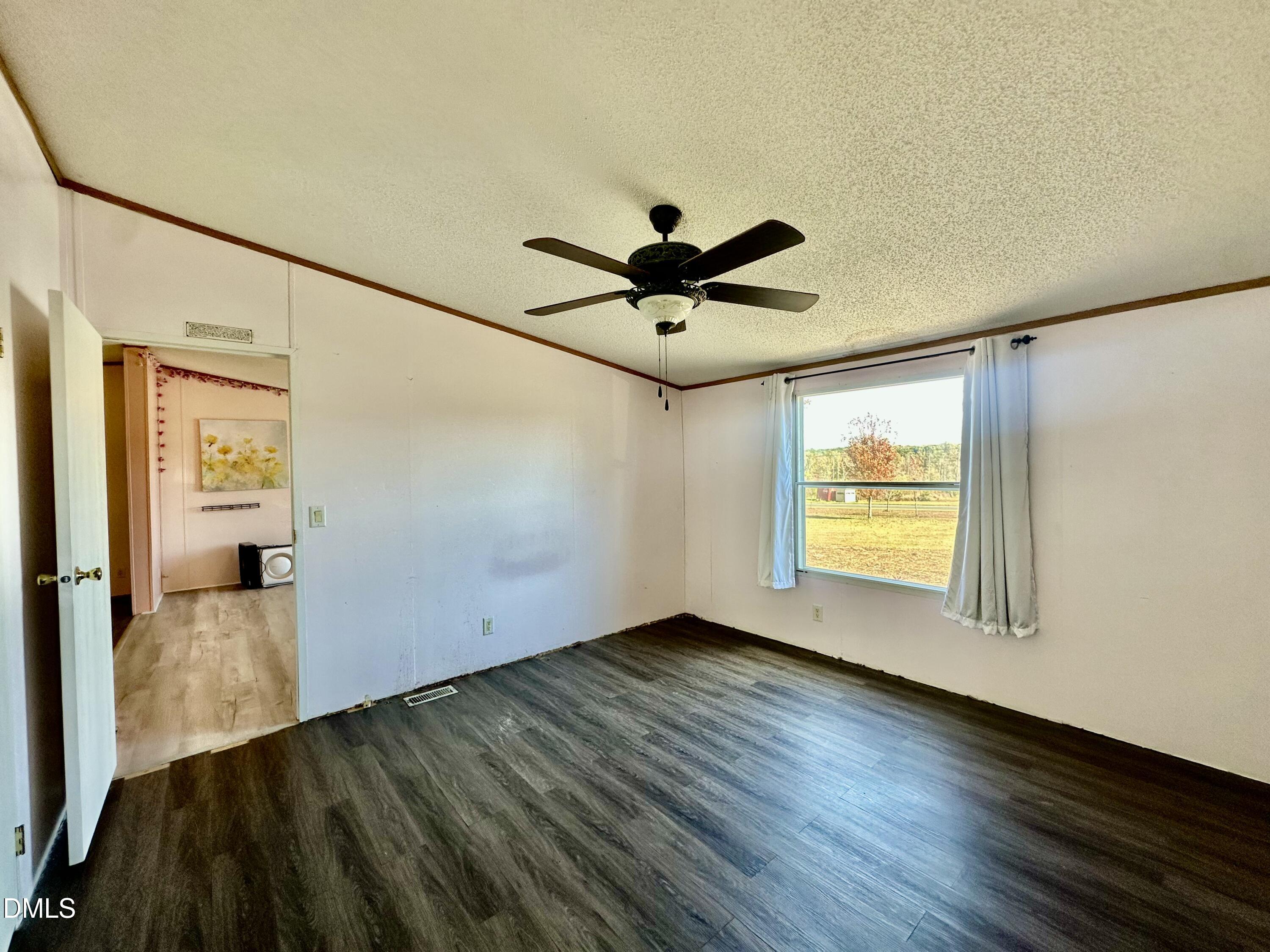287 Oliver Loop Road Roxboro, NC 27574 - Photo 14 of 26 a view of an empty room with a window and wooden floor