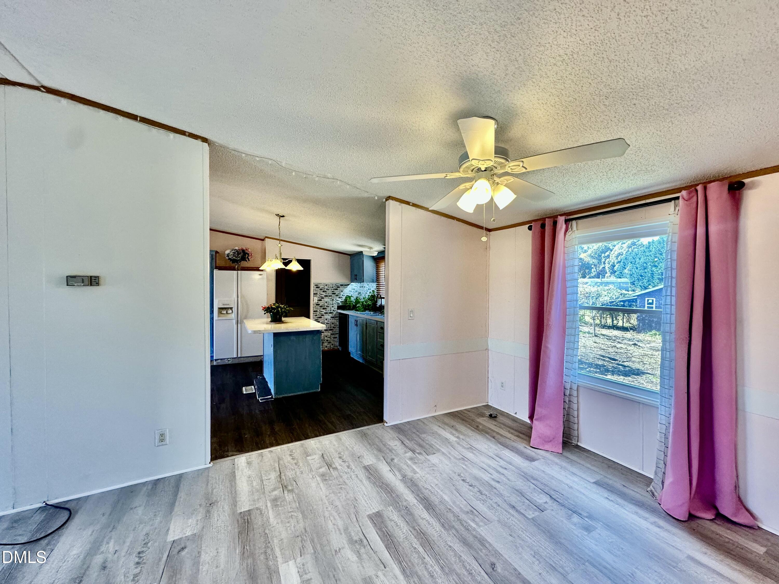 287 Oliver Loop Road Roxboro, NC 27574 - Photo 17 of 26 a kitchen view with wooden floor and a refrigerator