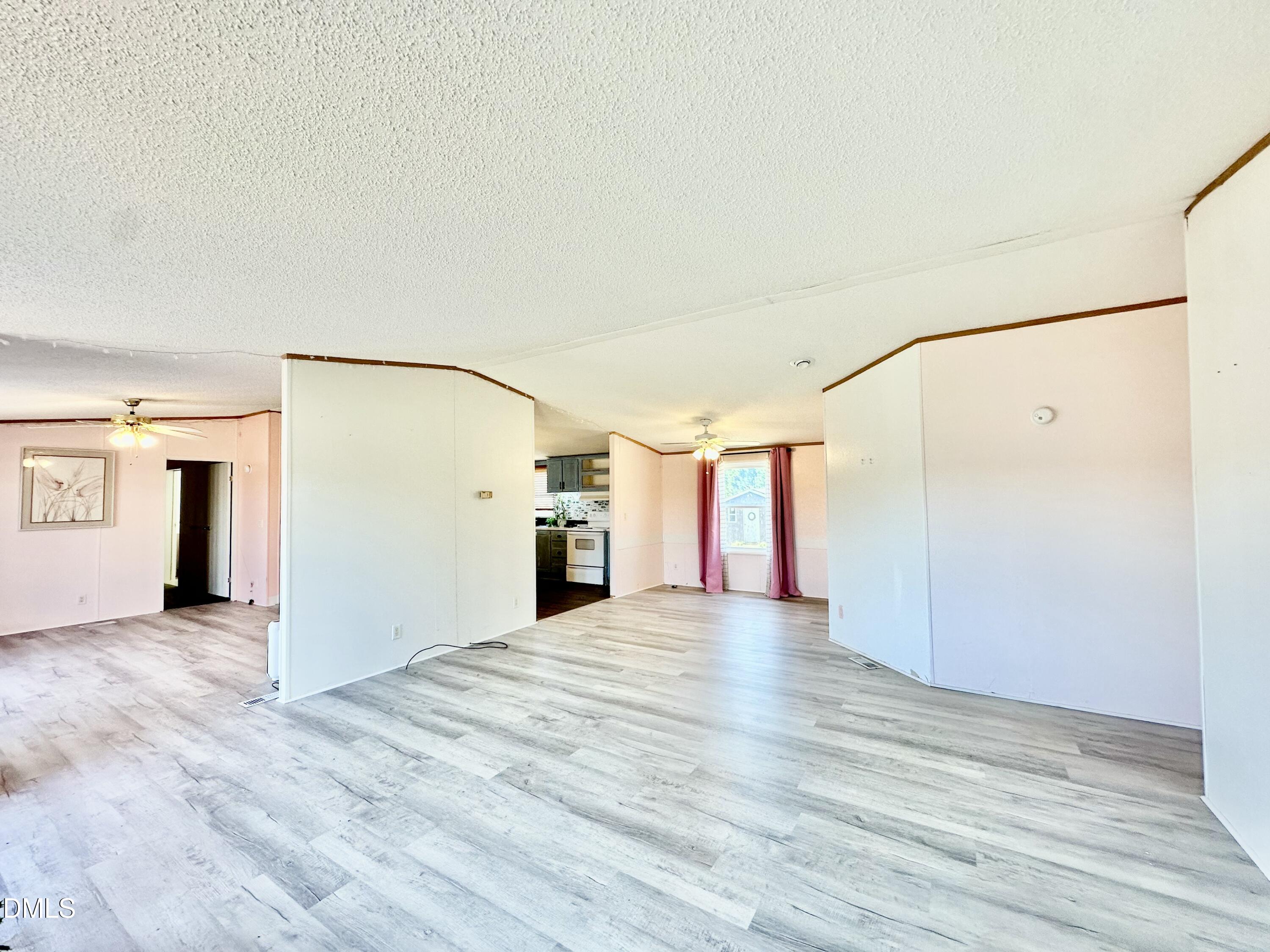 287 Oliver Loop Road Roxboro, NC 27574 - Photo 5 of 26 a view of a big room with wooden floor and windows