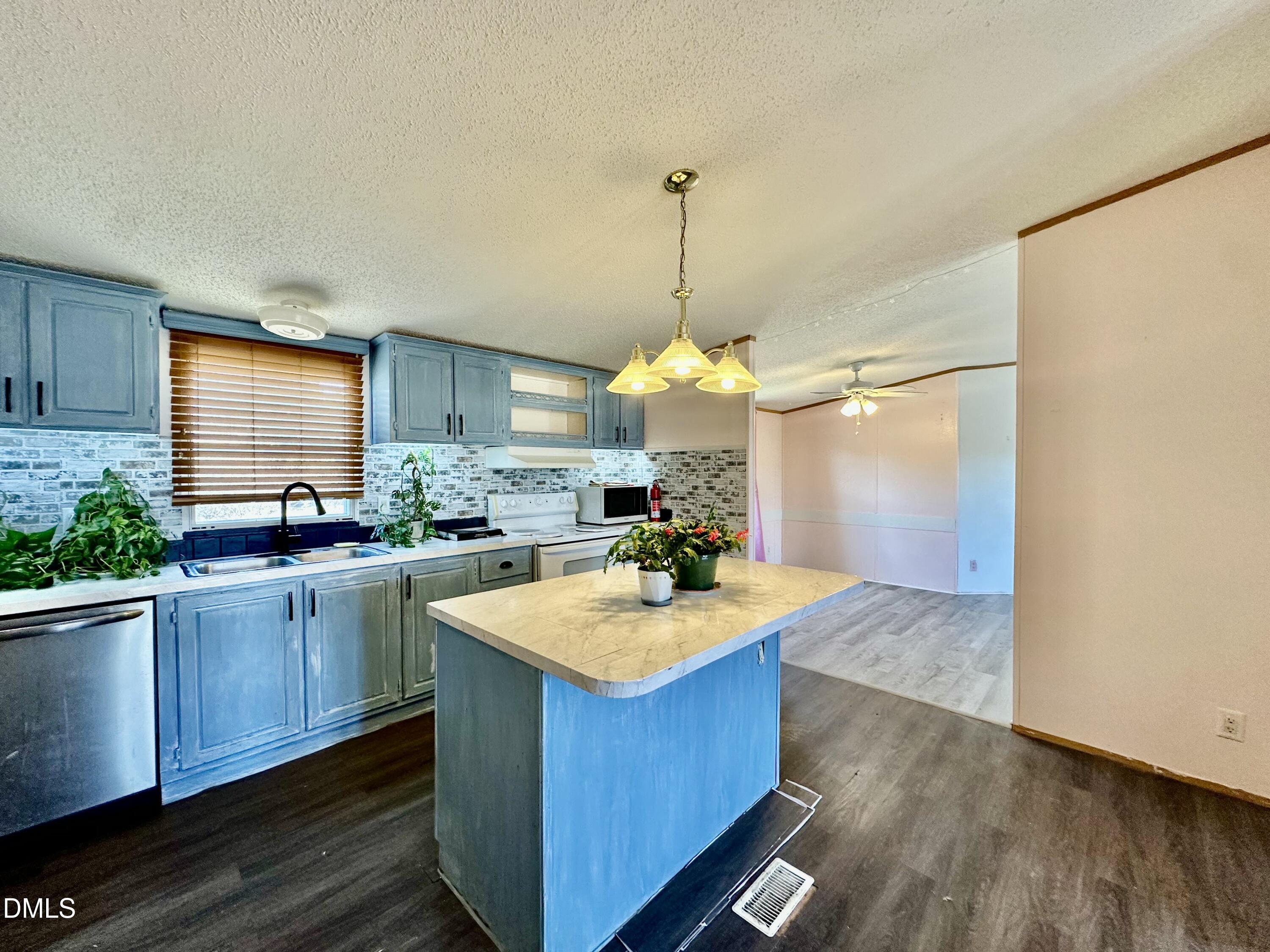 287 Oliver Loop Road Roxboro, NC 27574 - Photo 10 of 26 a kitchen with kitchen island granite countertop a sink cabinets and wooden floor