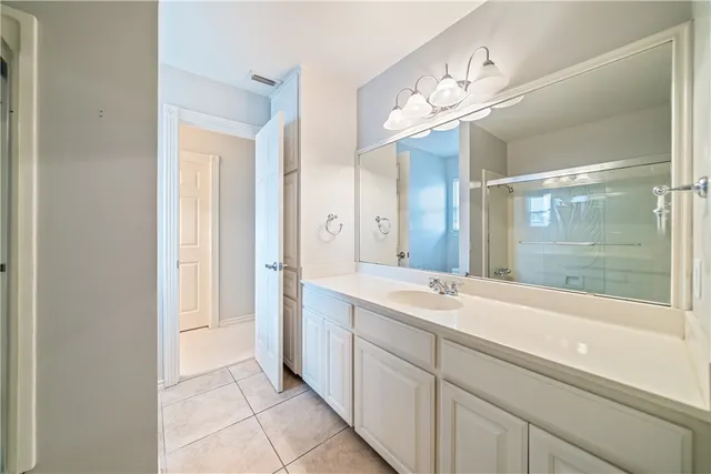 a spacious bathroom with a sink a large mirror and a shower