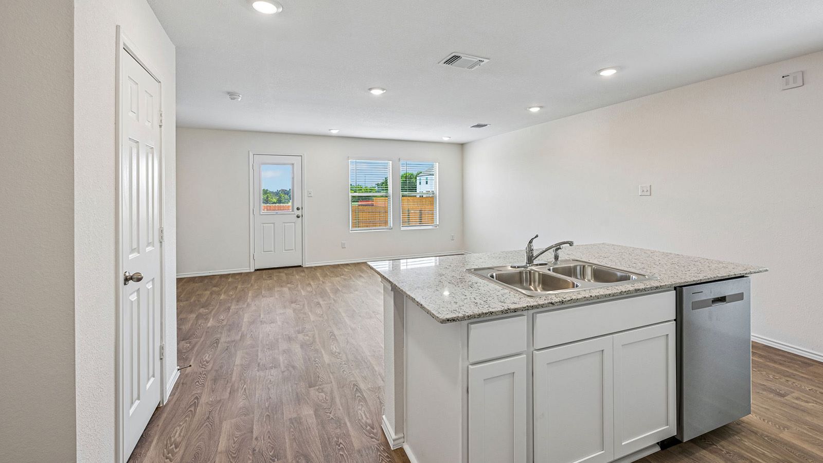 369 Old Stage Coach Road Jarrell, TX 76537 - Photo 6 of 25 Gleaming stone countertops and wood-look floors anchor this airy, open-concept kitchen and living area.