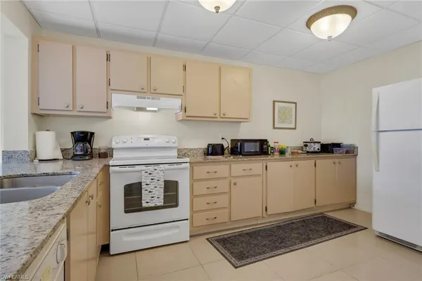 a kitchen with cabinets appliances a sink and a counter top space