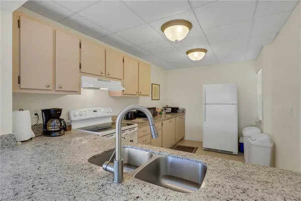 a kitchen with stainless steel appliances granite countertop a sink a stove and a refrigerator