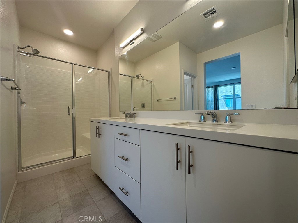 10517 Huxley Drive Rancho Cucamonga, CA 91730 - Photo 5 of 16 a bathroom with a double vanity sink mirror and shower