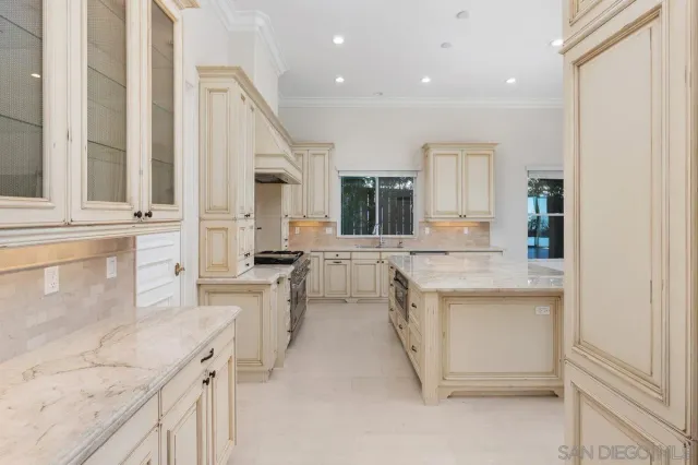 a large white kitchen with granite countertop a sink and dishwasher a stove with cabinets