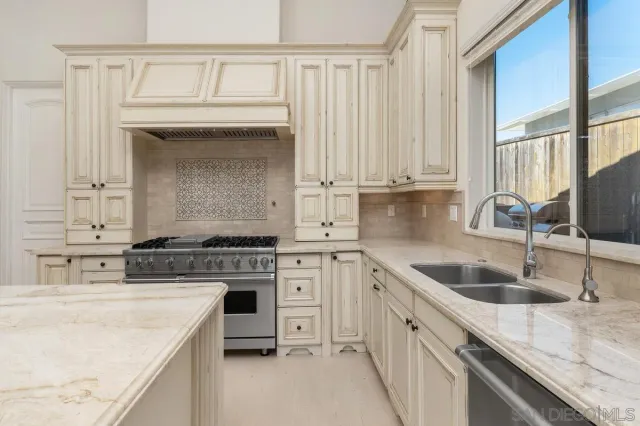 a kitchen with granite countertop a sink stove and cabinets