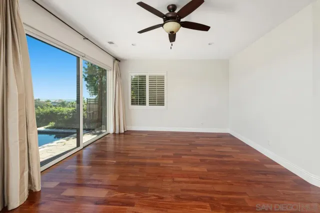 a view of a livingroom with a ceiling fan and wooden floor