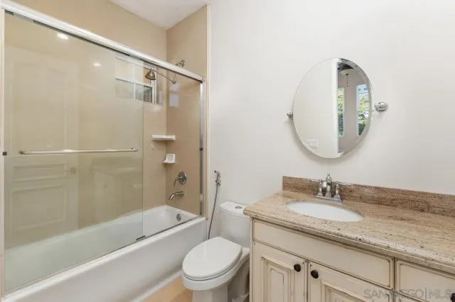 a bathroom with a granite countertop toilet a sink and bathtub