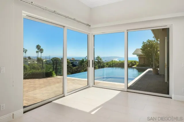 a view of a room with a large window and wooden floor