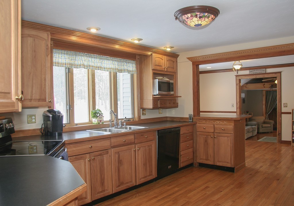52 Marlboro Road Berlin, MA 01503 - Photo 11 of 30 a kitchen with stainless steel appliances granite countertop a sink cabinets and wooden floor