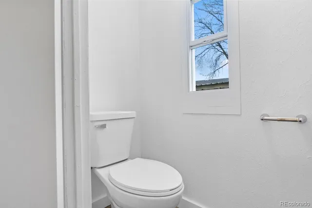 a white toilet sitting next to a shower