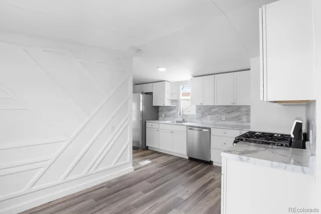 a kitchen with granite countertop white cabinets and white appliances