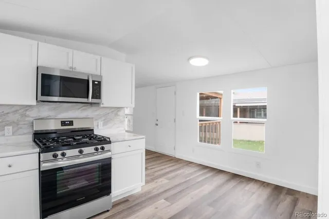a kitchen with stainless steel appliances a stove microwave and sink