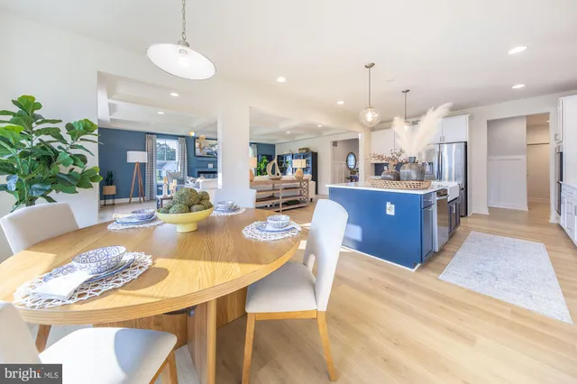 a view of a dining room and livingroom with furniture wooden floor a chandelier